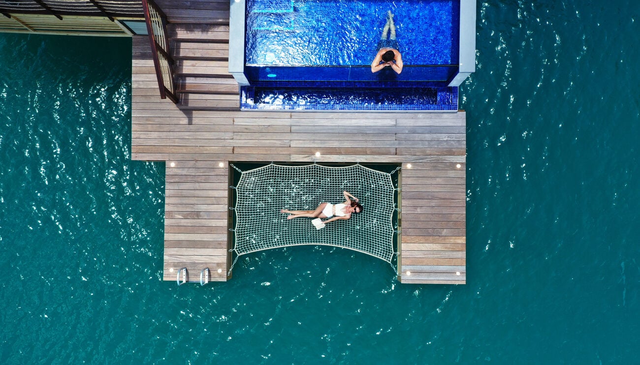 Woman on hammock overwater bungalow Caribbean