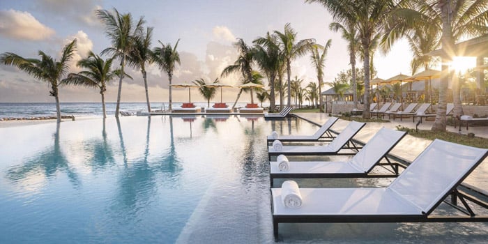 Pool lounge chairs during sunset